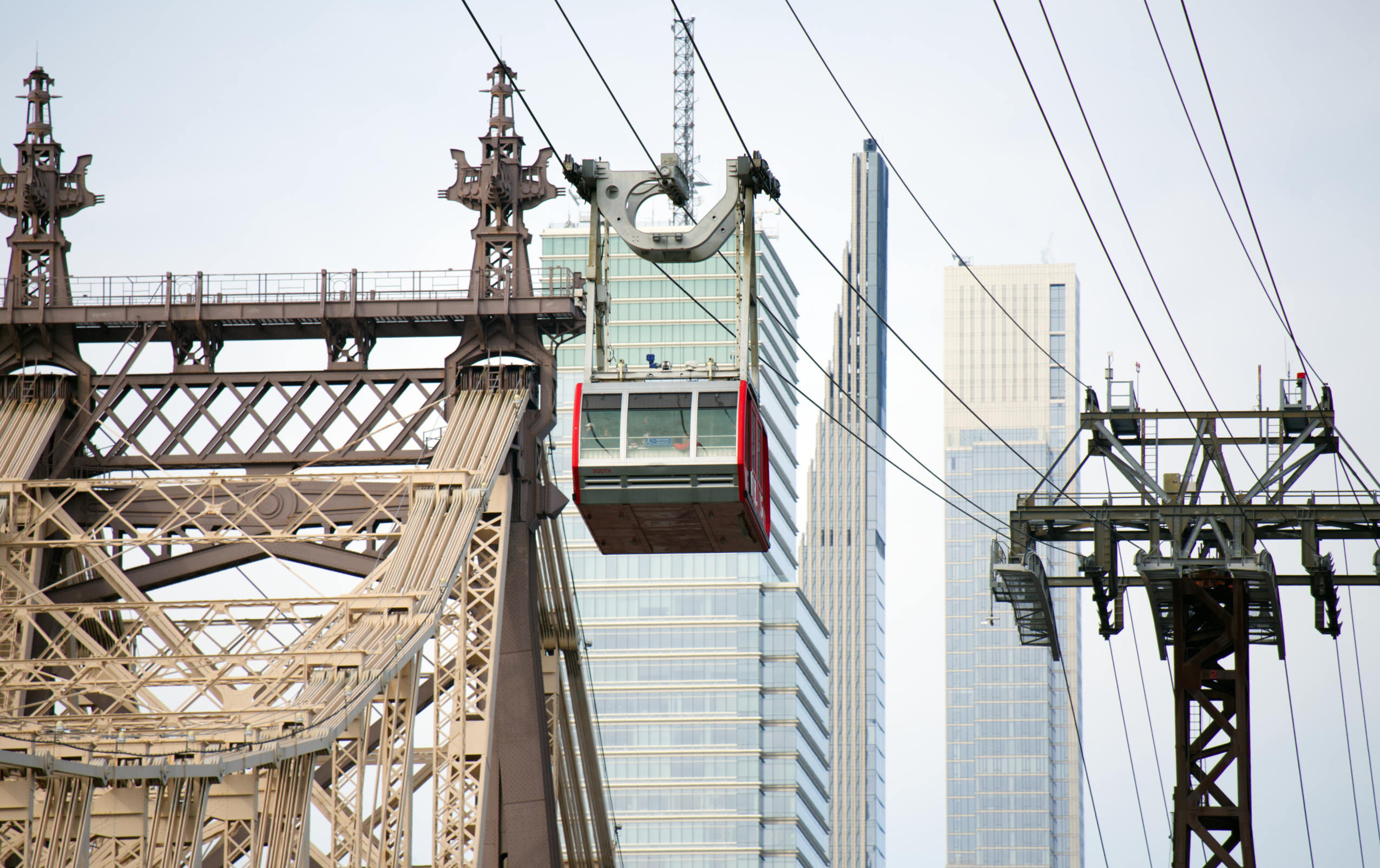 Die Seilbahn Roosevelt Island Tramway über dem East River in New York. Im Hintergrund sieht man Wolkenkratzer, links im Bild die Spitzen der Queensboro Bridge.